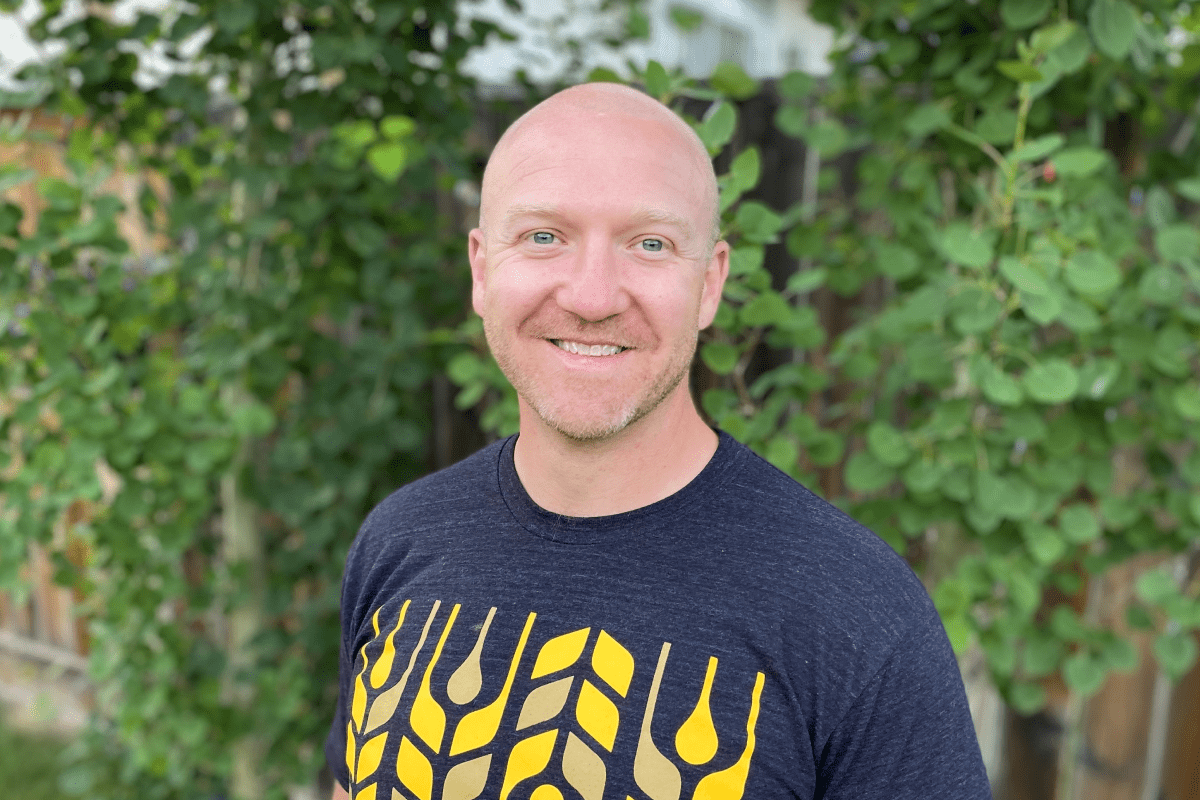 Man with no hair wearing yellow and black t-shirt