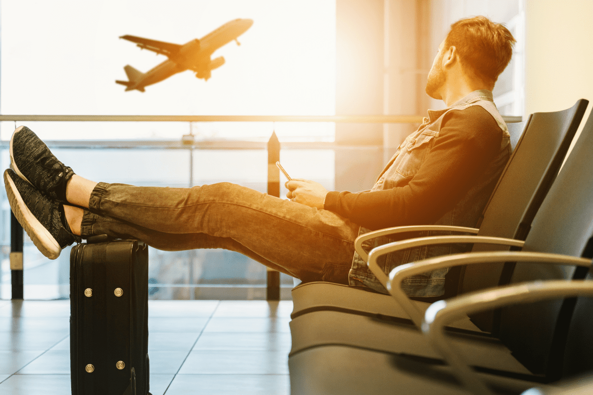 a person sitting in an airport with his feet on his side