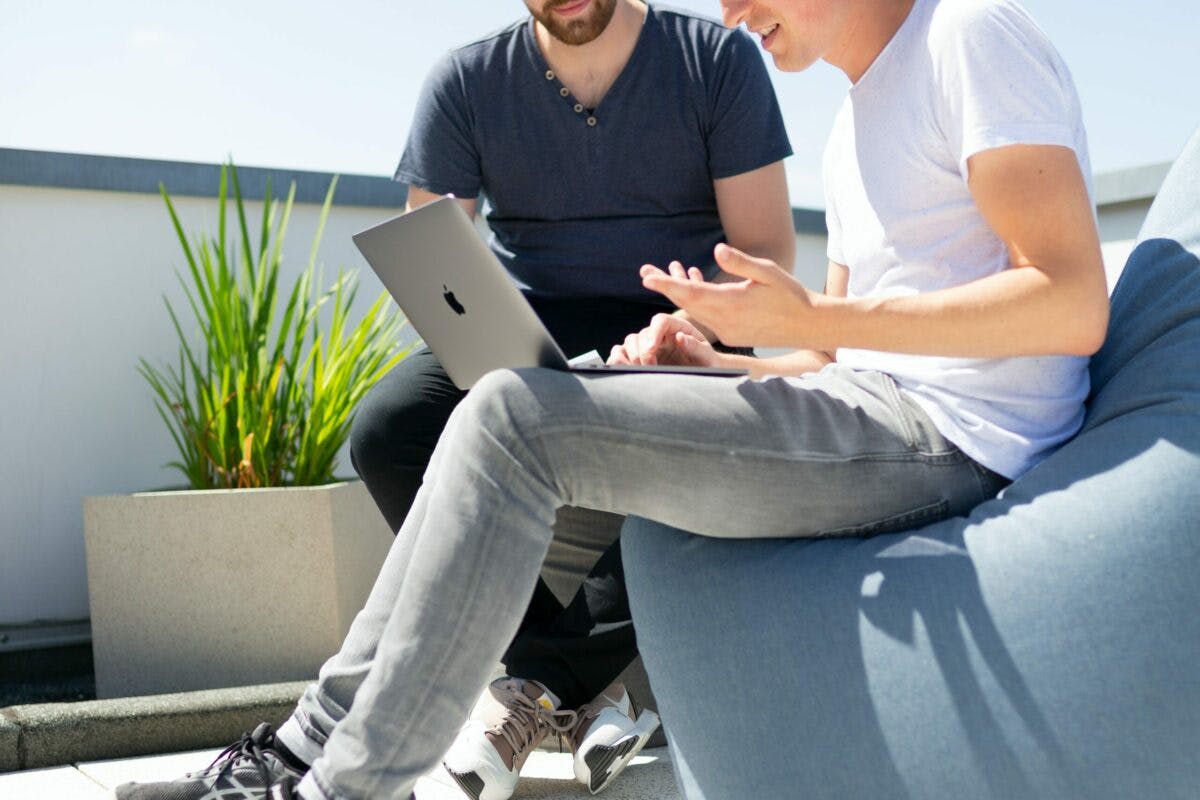 a person sitting on a bean bag with a laptop