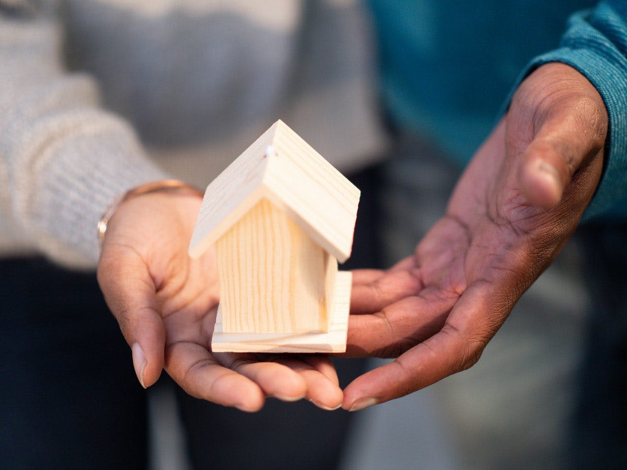 Couple holding wooden home