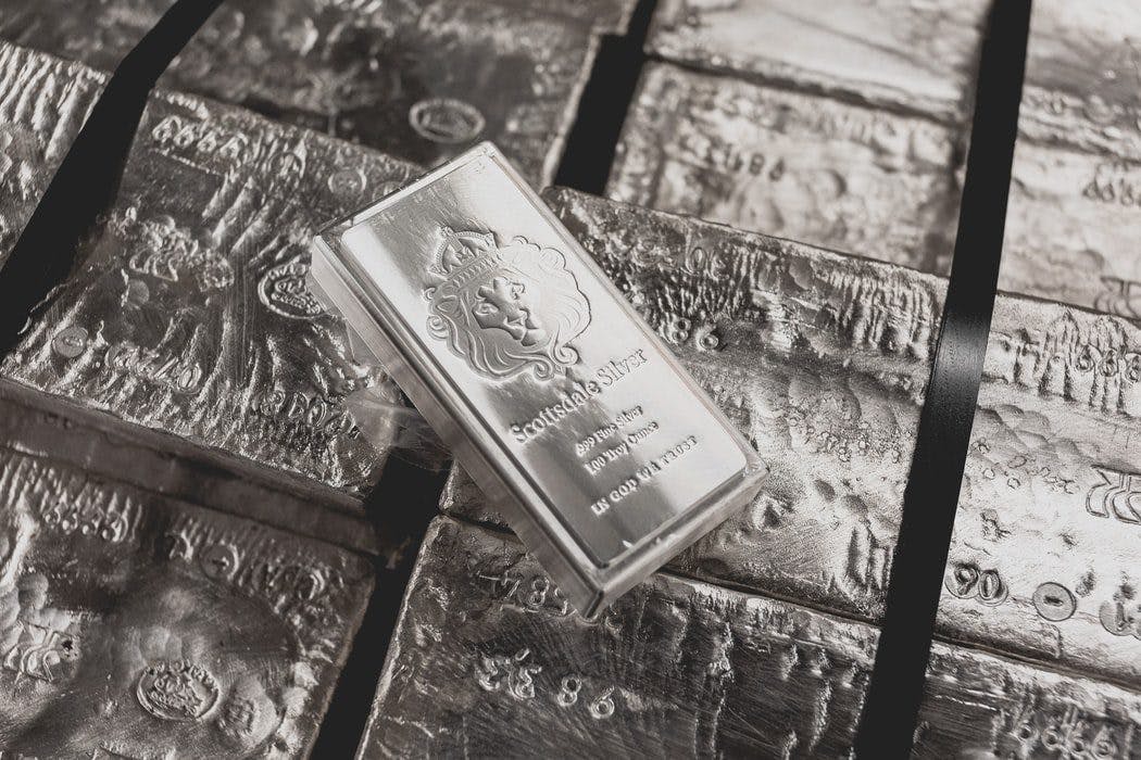 a silver bar on a pile of silver bricks