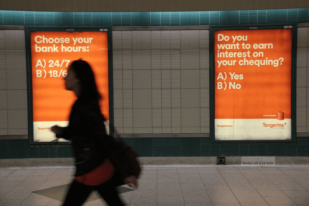 women walking in front of a Tangerine billboard