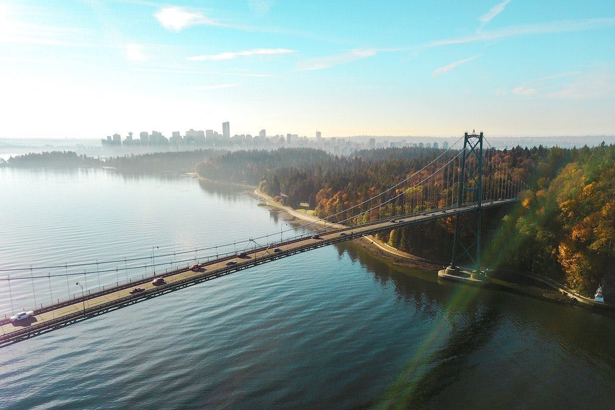 A cityscape with a bridge over water in the foreground.