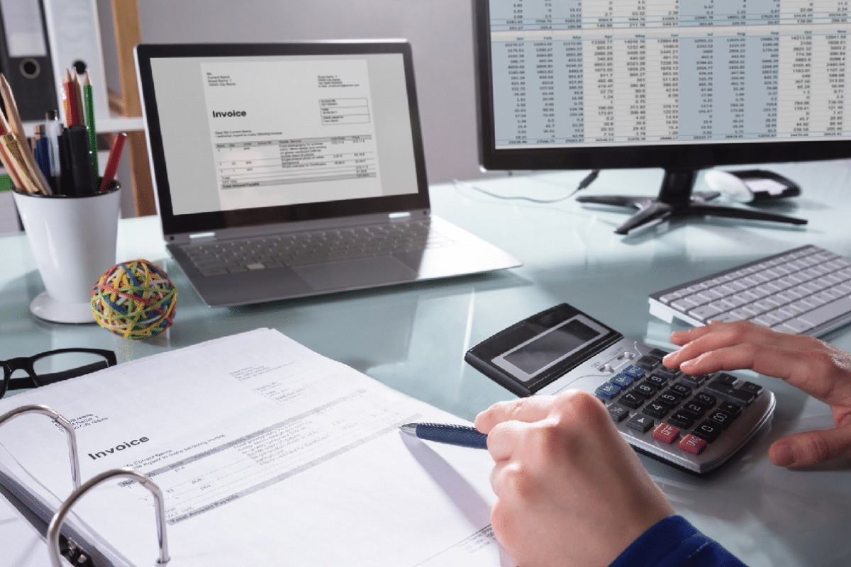 a person using a calculator and a laptop