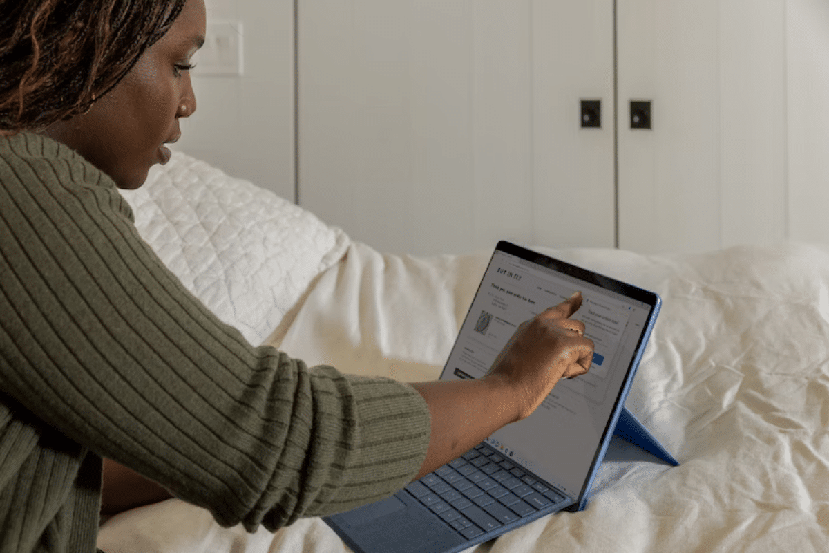 a person sitting on a bed using a laptop