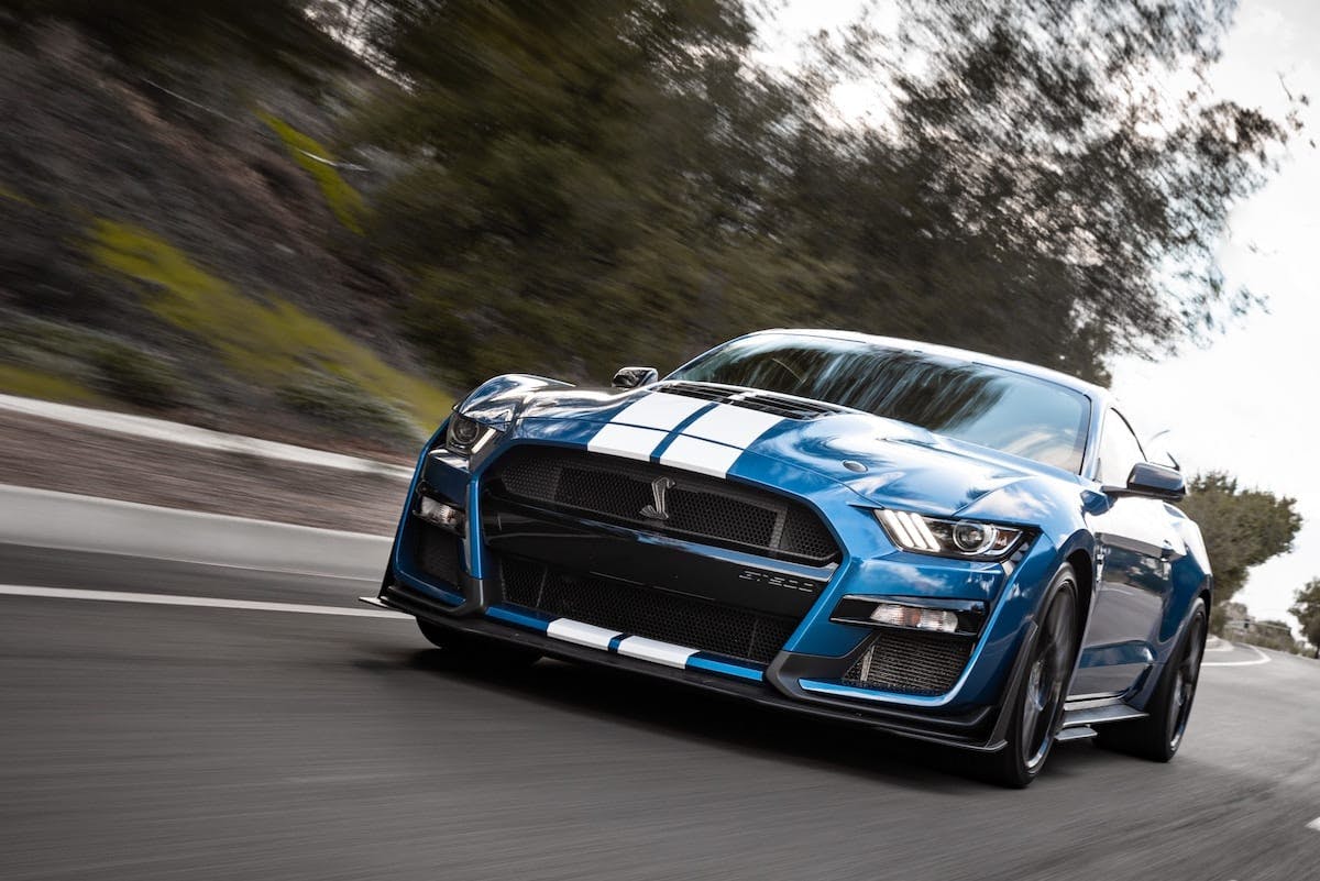 a blue sports car on a road