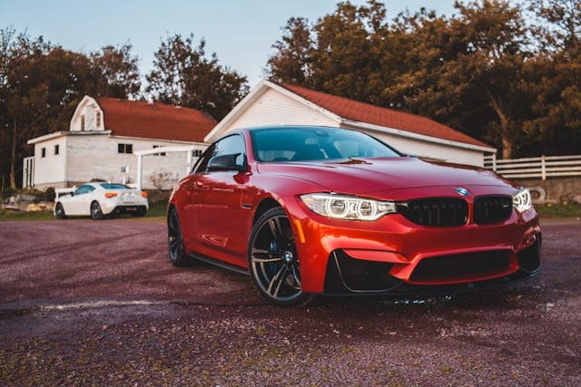 A BMW M4 showcasing a vibrant red exterior and sleek black wheels, exuding a captivating and stylish appeal.