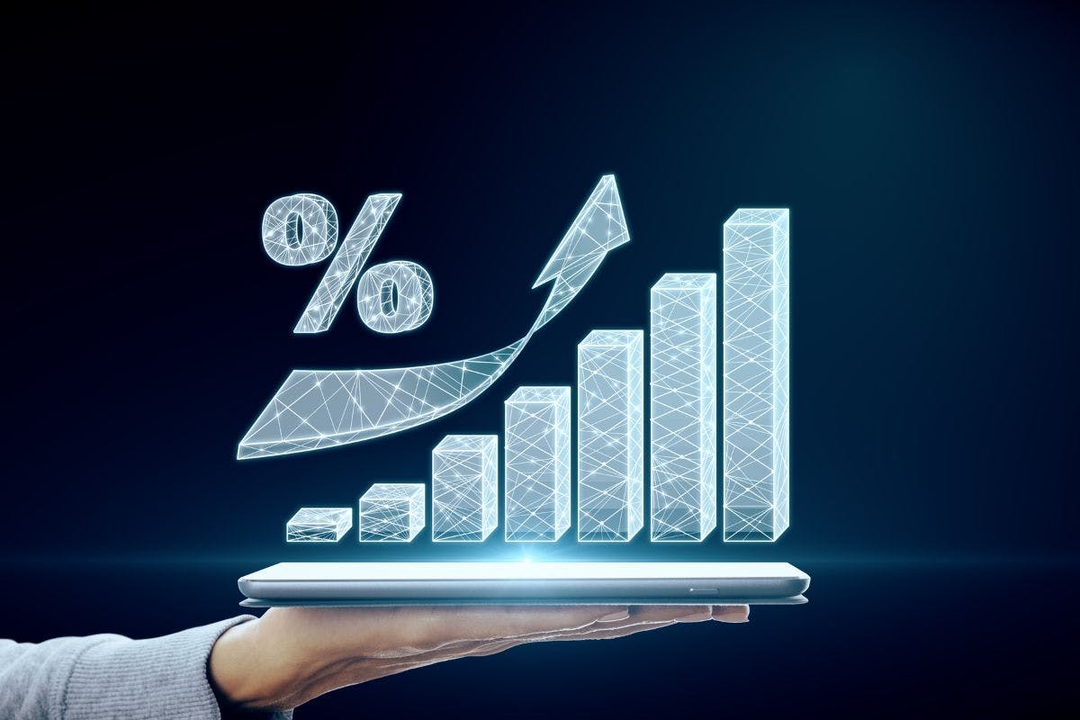 A hand holding smartphone that is projecting a graph that shows positive portfolio growth