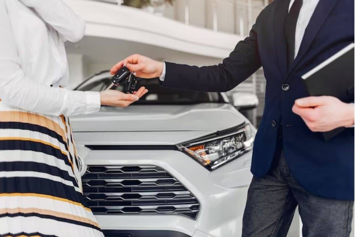 A man and woman standing beside a car, exuding confidence and style, ready to embark on a journey together.