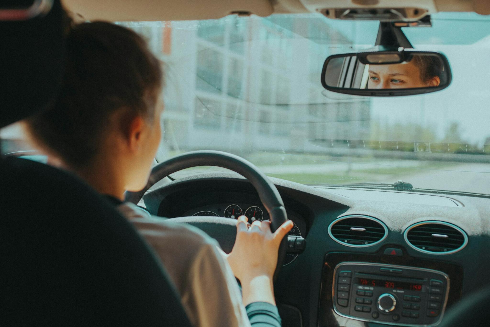 A woman driving a car with a man in the passenger seat.