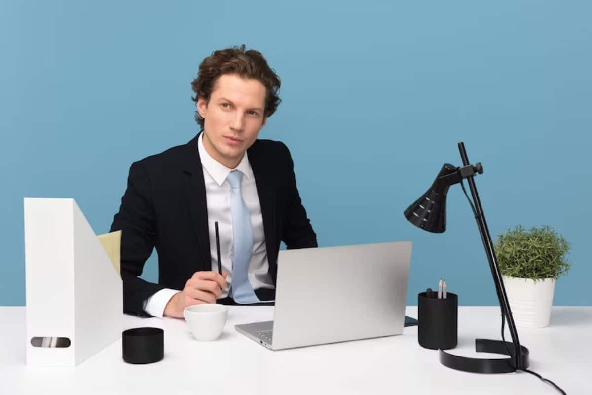 a person sitting at a desk with a laptop