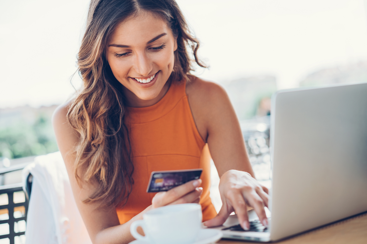 a person holding a credit card and using a laptop